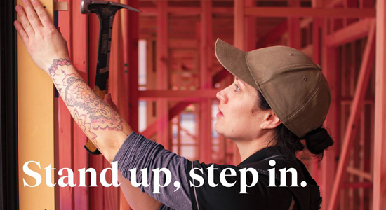 Woman builder hammering in a nail